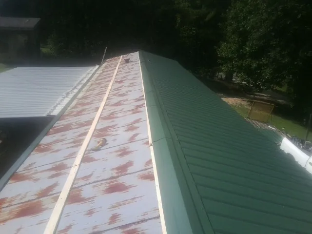 Old rusted panels beside newly installed green metal roofing — Wind Damage Roof Repair by Roofing Brothers in Hayfork