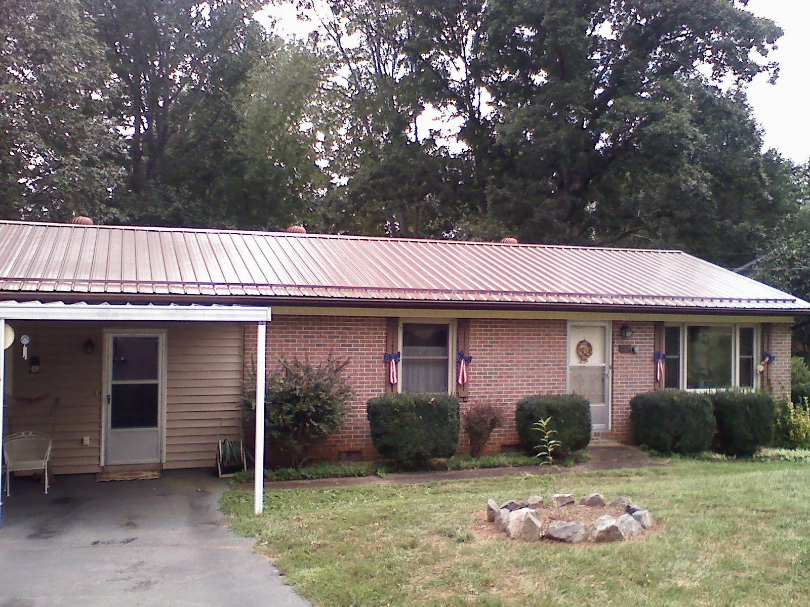 Bronze metal roof and carport on a brick ranch home — Roof Repair work by our crew in Hayfork